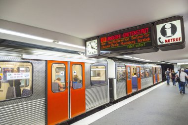 Tren hareket halinde olan metro istasyonunda insanlar