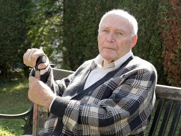 Alter mann genießt sitzen auf einer bank — Stockfoto