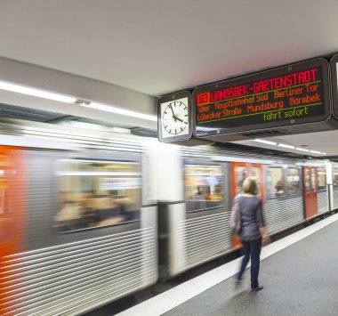 Tren hareket halinde olan metro istasyonunda insanlar