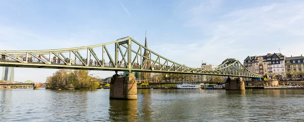 Personas en puente eiserner steg en Frankfurt con el río Main — Foto de Stock