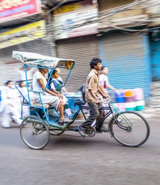 Rickshaw rider transports passenger early morning in Delhi clipart