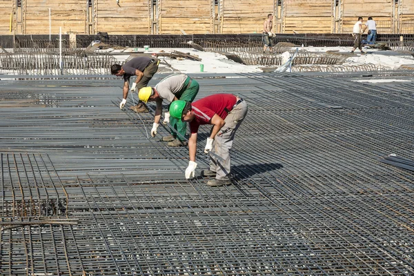 Trabajadores hacen la construcción de barras de acero en el sitio de construcción —  Fotos de Stock