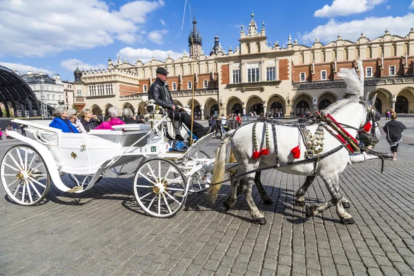Persone godono di carrozza trainata da cavalli in Piazza del Mercato — Foto Stock