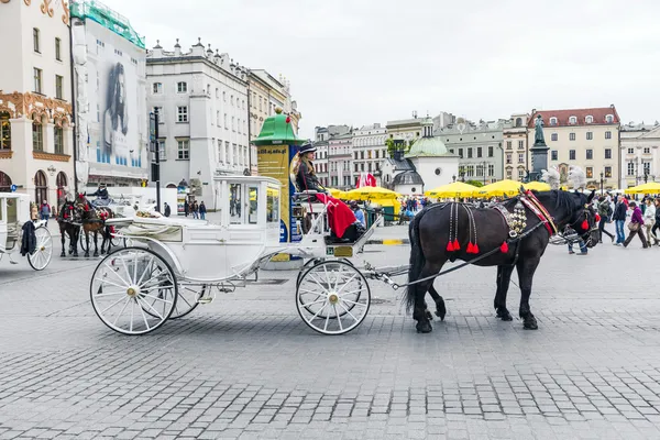 Les gens apprécient chariot tiré par des chevaux sur la place du marché — Photo