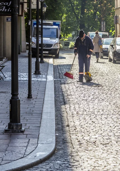 Homem limpa a rua de manhã — Fotografia de Stock