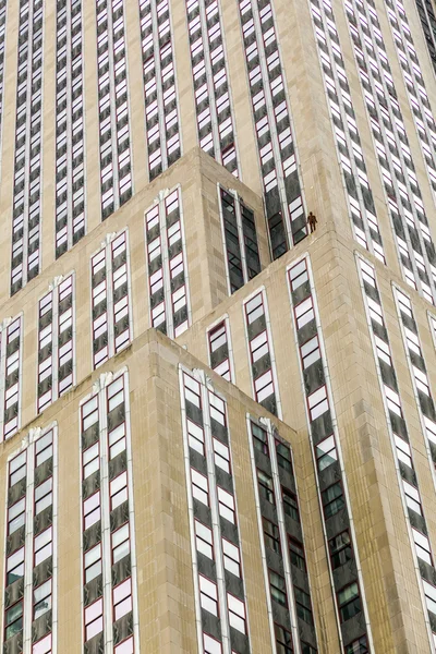 Fassade eines Wolkenkratzers mit Statue des Menschen — Stockfoto