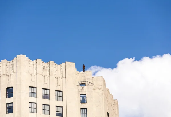 Iron statue of Man from artist Antony Gormley on the roof of a m — Stock Photo, Image