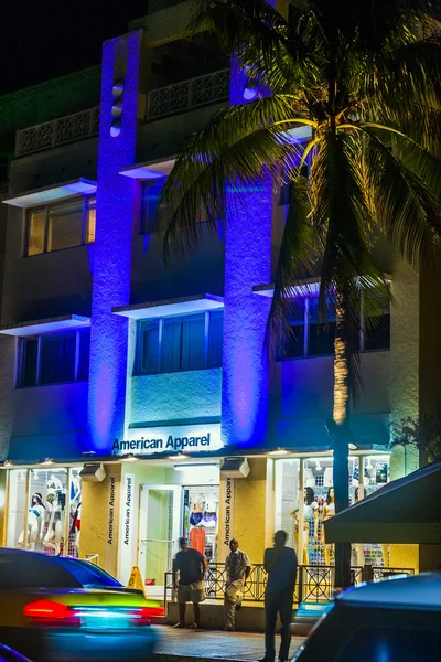 As pessoas gostam da vida noturna e vão às compras no Ocean Drive à noite — Fotografia de Stock