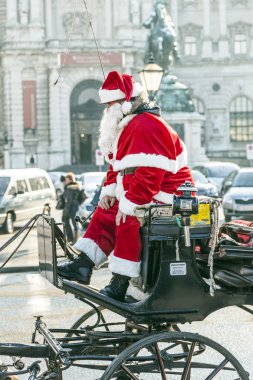 Fiaker 'ın şoförü kırmızı Noel Baba gibi giyinmiş.