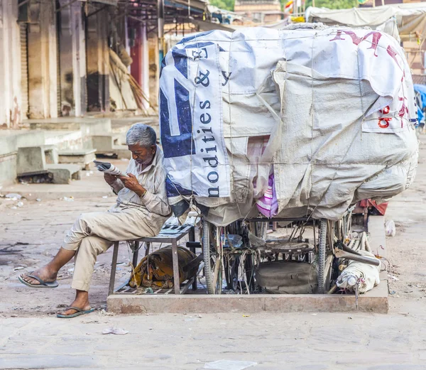Rickshaw man vilar och läser nyheter — Stockfoto