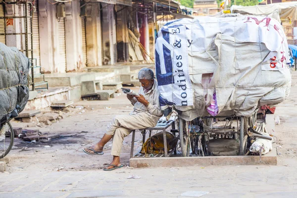 Rickshaw homme se repose et lit des nouvelles — Photo