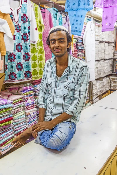 Pequeño dueño de la tienda indio hombre venta de chales y ropa en su s — Foto de Stock