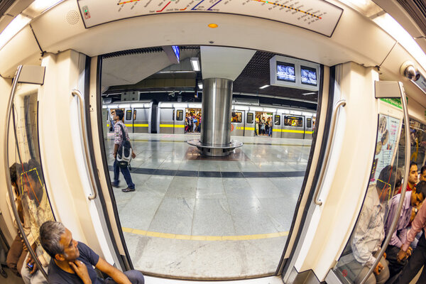 люди в поезде на станции метро в Дели
