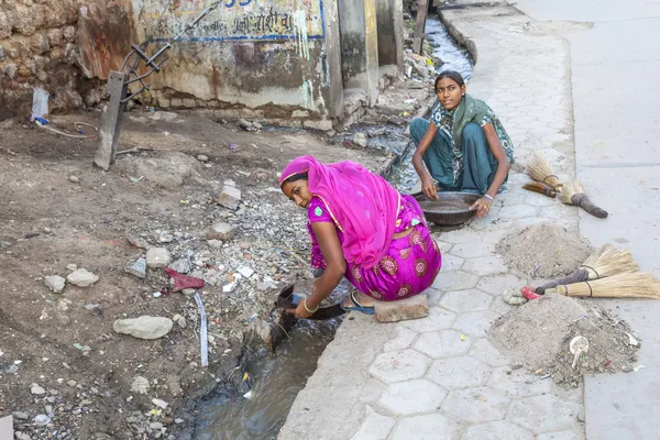 Woman tries to find gold dust in the canalisation — Stock Photo, Image