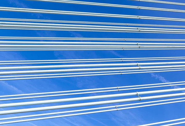 Pattern of steel wires of a bridge under blue sky — Stock Photo, Image