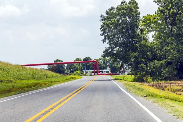 Conduttura rossa attraversa la strada — Foto Stock