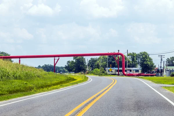 Conduttura rossa attraversa la strada — Foto Stock