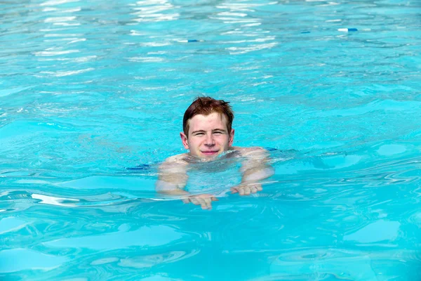 Menino se diverte nadando na piscina — Fotografia de Stock