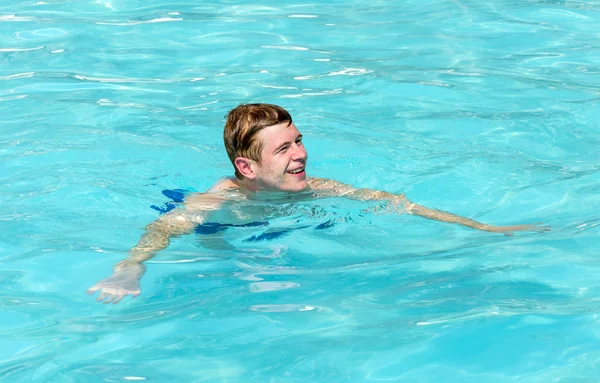 Jongen heeft leuke zwemmen in het zwembad — Stockfoto