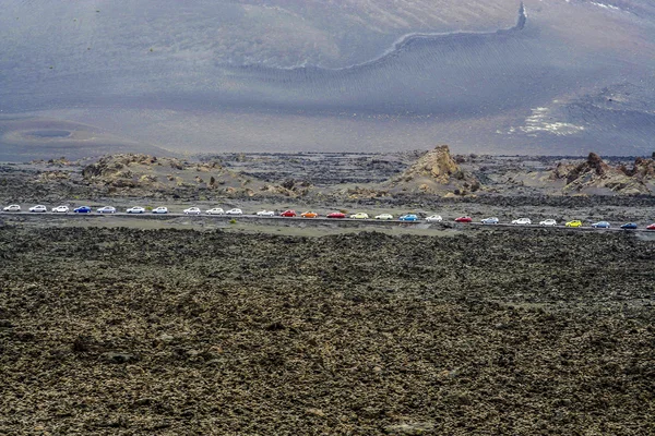 Mensen rijden met gehuurde auto's in nationaal park timanfaya aan se — Zdjęcie stockowe