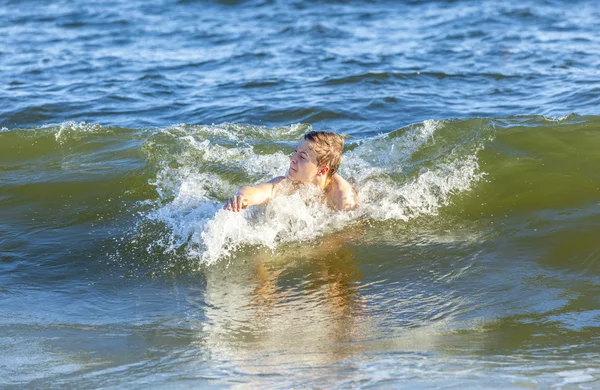 Αγόρι απολαμβάνει κολύμπι στα κύματα — Φωτογραφία Αρχείου