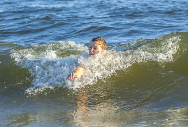 Αγόρι απολαμβάνει κολύμπι στα κύματα — Φωτογραφία Αρχείου