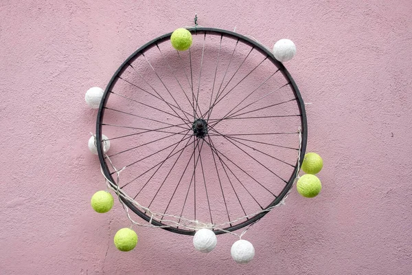 白と黄色のテニスボールで飾られたピンクの壁に自転車の車輪の詳細 — ストック写真