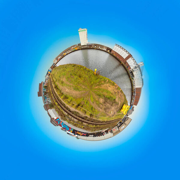 Dortmund, Germany - December 26, 2020:  old harbor in Dortmund as tiny planet with old dock buildings and rotten painted walls.