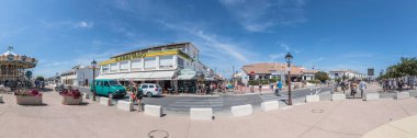 SAINTES MARIES DE LA MER, FRANCE - 15 YAŞI 2017: Saintes Maires de la Mer 'de insanlar gezinti güvertesi boyunca yürür. Eski zamanlarda küçük balıkçı köyü Camargue 'nin başkentiydi ama günümüzde hala Camargue' nin en büyük kentidir..