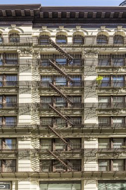 NEW YORK, ABD - OCT 5, 2017: New York 'taki eski tarihi bir evin cephesinde demir yangın merdiveni. 4 katlı ve daha fazla katlı her evin kanunen bir yangın merdivenine ihtiyacı vardı..