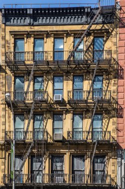 NEW YORK, ABD - OCT 5, 2017: New York 'taki eski tarihi bir evin cephesinde demir yangın merdiveni. 4 katlı ve daha fazla katlı her evin kanunen bir yangın merdivenine ihtiyacı vardı..
