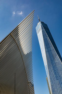 NEW YORK, ABD - OCT 6, 2017: Oculus ulaşım merkezinin ayırt edici mimari formu One World Trade Center kulesinin parlak manzarasının önünde duruyor.