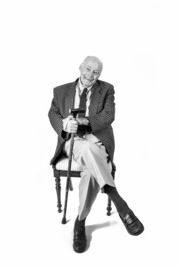 Beyaz bir arka plan oturan mutlu yaşlı adam