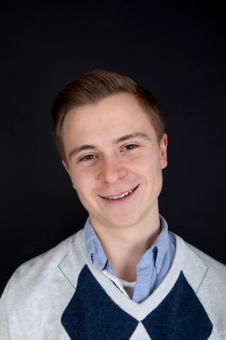 Yakışıklı bir çocuğun portresi. Kendinden emin ve gülümsüyor.