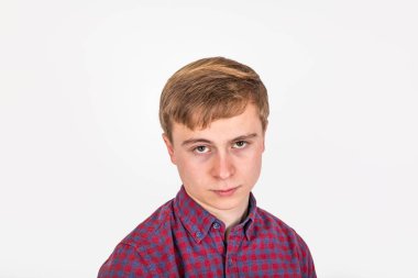 Stüdyoda izole edilmiş kızgın görünümlü bir gencin portresi.