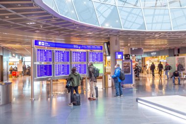 Frankfurt, Almanya - 7 Şubat 2022: insanlar çıkış ve çıkış uçuşları hakkında gerçek bilgiler almak için kalkış tahtasını izliyorlar.
