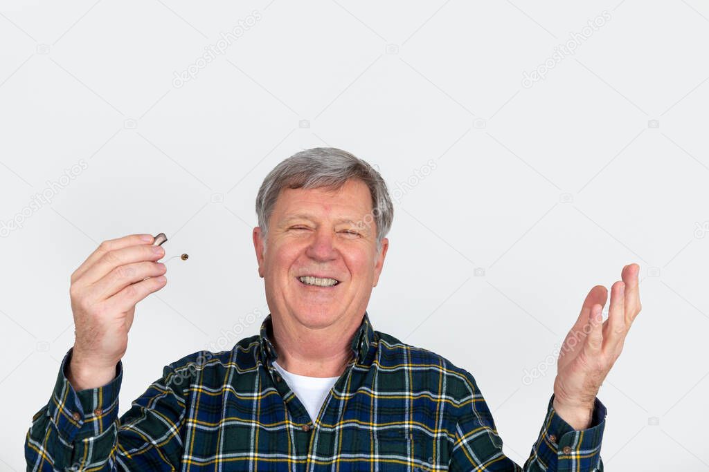 portrait of handsome smiling mature man isolated on white background with hearing aid