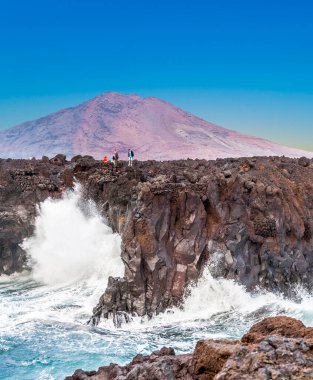 Playa Blanca, İspanya - 25 Aralık 2010: İnsanlar Playa Blanca, İspanya 'da büyük dalgalarla Los Hervideros' un güzel sahillerinin tadını çıkarıyorlar..