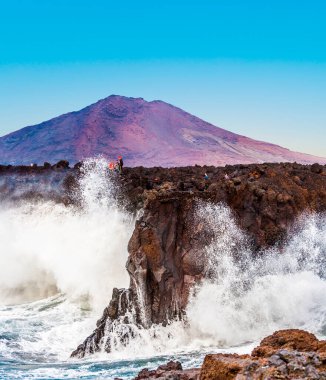 Playa Blanca, İspanya - 25 Aralık 2010: İnsanlar Playa Blanca, İspanya 'da büyük dalgalarla Los Hervideros' un güzel sahillerinin tadını çıkarıyorlar..