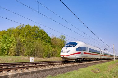 Raunheim, Almanya - 21 Nisan 2018: Deutsche Bahn 'ın Alman yüksek hızlı treni Intercity Express (ICE) treni Raunheim yakınlarındaki kırsal alandan geçer. ICE 3 sınıfı tren Siemens tarafından üretiliyor..