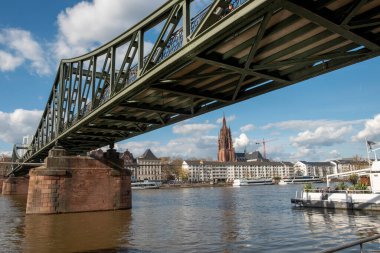 Frankfurt, Almanya - 10 Nisan 2022: Frankfurt am Main ufuk çizgisi ile eski yaya köprüsü Eiserner Steg engl: Demir köprü.