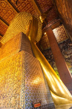 Bangkok, Tayland - 4 Ocak 2010: Bangkok, Tayland 'daki Wat Pho tapınağında uzanan Buda heykelinin ayrıntıları. Heykel 15 metre yüksekliğinde ve 43 metre uzunluğunda. Sağ kolu başının üstünde duruyor..