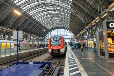 Frankfurt, Almanya - 15 Şubat 2022: İnsanlar Frankfurt Tren İstasyonu 'ndaki trene yetişmek için acele ediyorlar. Tarihi tren istasyonu 1898 civarında klasik tarzda inşa edildi..