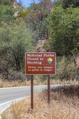 Three Rivers, USA - May 21, 2022: signage national parks closed to hunting - firing any weapon in parks is strictly illegal in the sequoia national park.