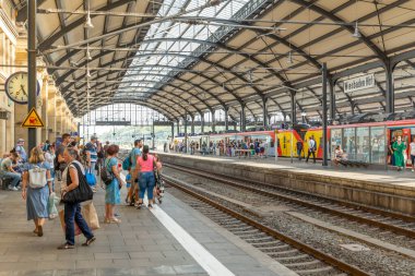 Wiesbaden, Germany - August 17, 2022: people at the train station in Wiesbaden waiting at the platform for the train.