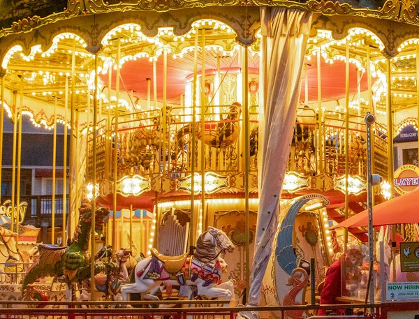 San Francisco, USA - June 5, 2022: Pier 39 carousel built in Italy with 30 animals seen at night showing yellow, orange bright lights.