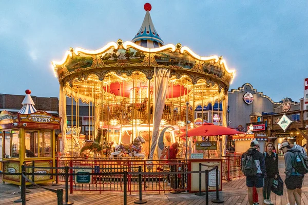 San Francisco, USA - June 5, 2022: Pier 39 carousel built in Italy with 30 animals seen at night showing yellow, orange bright lights.