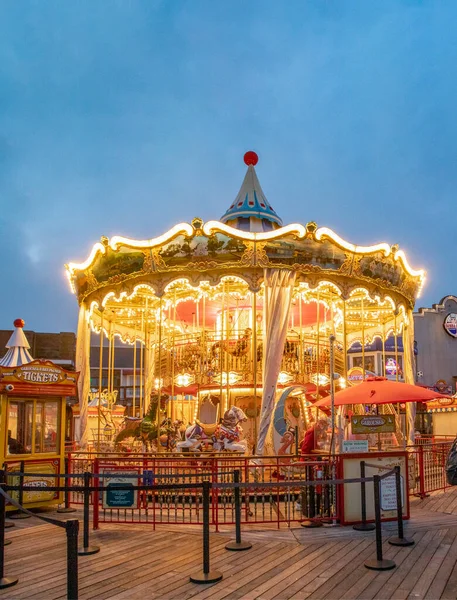 San Francisco, USA - June 5, 2022: Pier 39 carousel built in Italy with 30 animals seen at night showing yellow, orange bright lights.