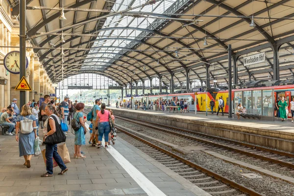 Wiesbaden, Germany - August 17, 2022: people at the train station in Wiesbaden waiting at the platform for the train.