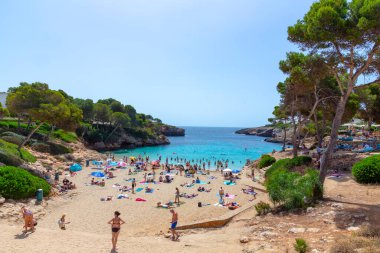 Cala d 'Or, İspanya - 22 Haziran 2022: İnsanlar Cala d' or 'daki Esmeralda plajında yüzmeyi ve dinlenmeyi seviyorlar..